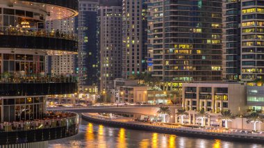 Dubai Marina rıhtımı kuleleri ve Dubai 'deki alışveriş merkezinin balkonundan restoranlara yakın köprüsü olan Birleşik Arap Emirlikleri hava geçiş zamanı..