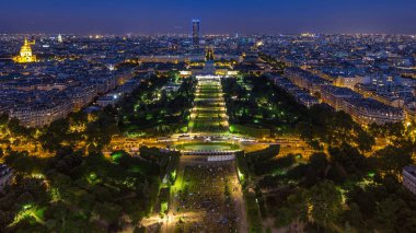 Mars Sahası ile birlikte büyük bir şehrin gökyüzü manzarası ve gün batımından sonra parktan geceye geçiş zamanı. Eyfel Kulesi 'nin gözlem güvertesinin üst görüntüsü. Paris, Fransa.