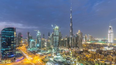 Dubai Şehir Merkezi 'nden geceye geçiş panoramik zaman dilimi. Geceleri büyük, fütüristik şehir üzerinde hava manzarası. Dubai 'nin gökdelenleri, Birleşik Arap Emirlikleri. Akşam gökyüzü çatıdan yükseliyor