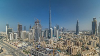 Dubai şehir merkezindeki güzel lüks hava manzarası, gölgeler, Dubai, Birleşik Arap Emirlikleri. Turuncu gökyüzünde renkli bulutlar olan iş hangarı kulelerinden çatı manzarası. Yolda trafik vardı.