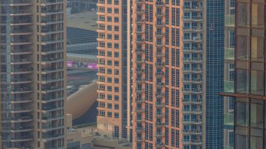 Dubai şehir silüetinin gün geçiş timelapse yukarıdan Dubai Marina'da gecesine gökdelenler ile. Havadan görünümü. Trafik yol ve metro istasyonu