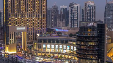 Dubai, Birleşik Arap Emirlikleri güneş battıktan sonra gece geçiş timelapse alışveriş merkezi ve Dubai Marina restoranlarda günler güzel hava üstten görünüm. Modern kuleleri ve yolda trafik.