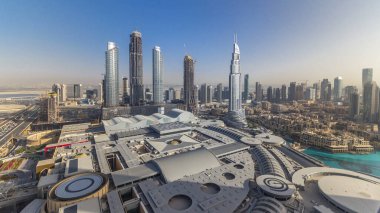 Dubai şehir merkezinde tüm gün boyunca modern gökdelenler, alışveriş merkezleri ve yollarda trafik vardı. Yukarıdan en iyi panoramik görüntü. Gölgeler çok hızlı hareket ediyor