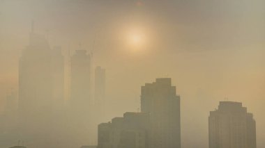 Sisli sabah gündoğumu Dubai timelapse şehir merkezinde. Şehir gökdelenler fütüristik görünümünü sis kaplı. Çatı modern kuleli havadan görünümden. Dubai, Birleşik Arap Emirlikleri
