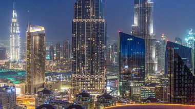 Dubai şehir merkezi, UAE 'nin en yüksek binası ve karayolu trafiğiyle gece gündüz geçiş zamanı. Günbatımından sonra modern kulelerle gökdelenin çatısından gökyüzü manzarası