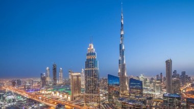 Dubai şehir merkezindeki Panorama 'dan gece, gündüz en yüksek binayla ve Şeyh Zayed karayolu trafiğiyle geçiş zamanı. Günbatımından sonra modern kulelerle gökdelenin çatısından gökyüzü manzarası