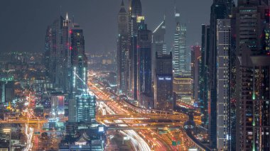 Dubai şehir merkezinde gökdelenler ve Gece geçiş timelapse, Dubai, Birleşik Arap Emirlikleri Şeyh Zayed yol gün havadan görünümü. Modern kuleler ve karayolu üzerinde akşam trafiği