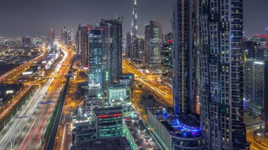 Dubai, Bae gece geçiş timelapse için şeyh zayed yol gün modern gökdelenler ve trafik ile Akşam silueti. İş koyu mimarisinin havadan görünümü.
