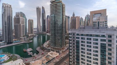 Dubai Marina yerleşim ve ofis gökdelenlerinin deniz manzarası. Yüzen tekneler ve yatlar. Sabah bulutlu bir gökyüzü
