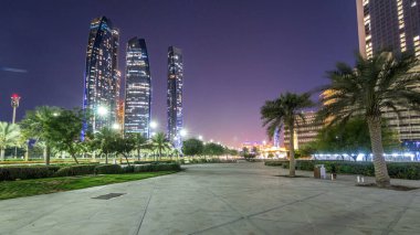Ebu Dabi 'nin gökdelenleri Etihad Kuleleri' nin binalarıyla aydınlandı. Gece gündüz geçiş zamanları. Avuç içleri parka yakın. Birleşik Arap Emirlikleri