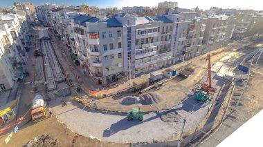 Beton, yol onarım şantiyesinde çok sayıda işçi ve mikser zaman ayarlı çalışıyor. Tramvay raylarının yeniden inşası. Tüm gün boyunca hava üst görünümü