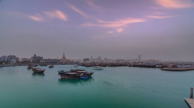 Geleneksel ahşap Dhow balıkçı tekneleriyle Doha Körfezi 'nde gün batımı. Corniche, Doha, Katar ile müzeden görüntü