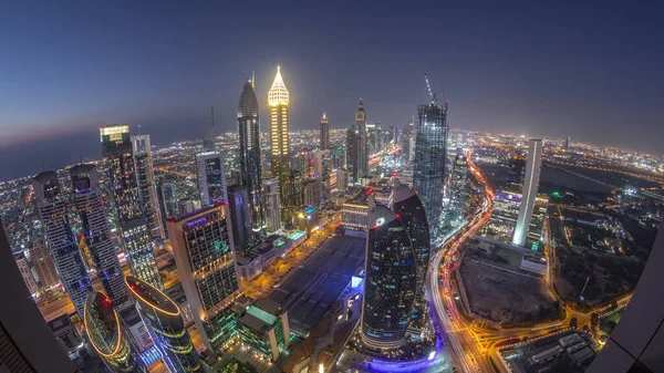 Sheikh Zayed Yolu yakınlarındaki binaların silueti ve Dubai, BAE 'deki hava gününden geceye geçiş. Günbatımından sonra finans merkezinde ve şehir merkezinde park yeri olan modern kuleler ve gökdelenler.