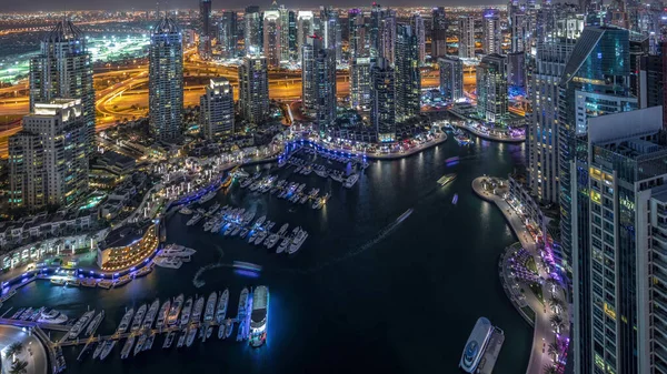 Dubai Marina gökdelenleri ve Jumeirah göl kuleleri Birleşik Arap Emirlikleri 'nde hava gününden geceye geçiş zamanlarını gösteriyor. Yolda trafik ve yüzen yatlar.
