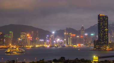 Hong Kong 'dan gece geçişi, Kowloon Körfezi' nden hava görüntüsü şehir merkezindeki zaman dilimi büyük gemi ve çatıdaki kuleler.