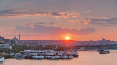 İstanbul 'un ufuk çizgisi İstanbul' da, günbatımında Boğaziçi ve Altın Boynuz 'daki tekne istasyonu yakınlarında çok sayıda yolcu feribotu bulunuyor. Arka planda cami ve köprü, bahar akşamında suyun yansımasıyla
