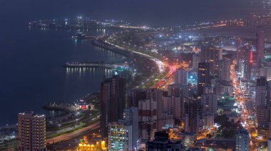 Kuveyt şehir merkezindeki gökdelenler ile gece gündüz geçiş zamanları alacakaranlıkta aydınlandı. Çatıdan hava görüntüsü. Kuveyt Şehri, Orta Doğu.
