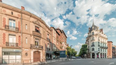 Panorama, Fransa 'nın Toulouse kentindeki Rue du Languedoc ve Theodore Ozenne kavşağında tarihi tuğla cephelerini gösteriyor. Canlı şehir merkezindeki Carmes metro istasyonu yakınlarındaki dükkanlar, kafeler, yol trafiği