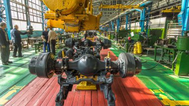 Konveyör montajı, traktörün gövdesini büyük endüstriyel fabrika zaman diliminde sahneleyecek. Çerçeve montajının aşaması, kurulum parçaları.