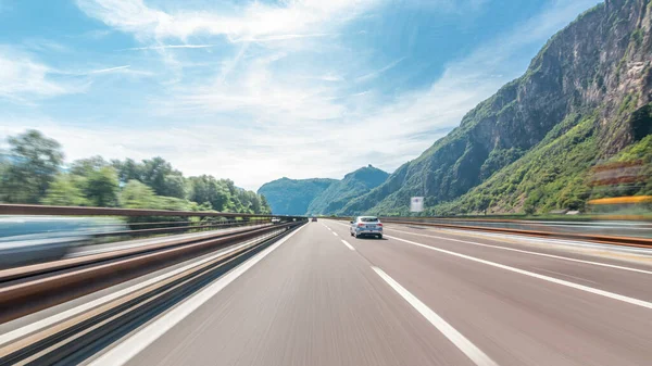 Dağlar ve çayırlar İtalya timelapse hyperlapse drivelapse içinde bir otoyolda sürüş. Elektrik direkleri, güzel manzara ve mavi gökyüzü ile beyaz bulutlar. Yüksek hız