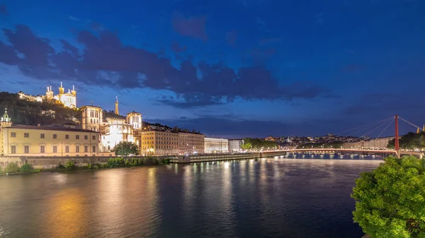 Aziz John 'un Vaftizci Katedrali ve Lyon' daki Notre-Dame de Fourviere Bazilikası 'nın zaman çizelgesi, günden geceye değişiyor. Yansıtılmış rıhtım ve nehirde yansıyan binalar. Fransa