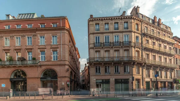 Toulouse, Occitanie, Fransa 'da Rue de Metz' in zaman çizelgesini gösteren panorama, tarihi cepheleri, dükkanları, kafeleri, trafiği ve mavi bulutlu gökyüzünü gösteriyor. Şehrin göbeğinde canlı bir şehir manzarası