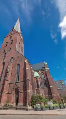 St. Peters Kilisesi ya da Hauptkirche St. Petri zaman atlaması Hamburg, Almanya 'da. Bu Protestan Luteryan kilisesinde yüksek kulesi, trafiği ve mavi gökyüzü arkaplanı olan gotik mimari yer almaktadır.