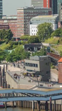 Jan Fedder Gezinti Alanı Hamburg, Almanya 'da canlı bir liman bölgesi. Gemiler ve tekneler Elbe Nehri 'nde ve arkasında ünlü binalar var. Rahatlama ve manzaralı güzellik