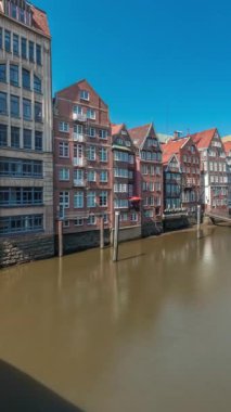 Kleines Rıhtımı 'nın Hamburg, Almanya' da bulunan Elbe Kanalı 'nın kuzeyindeki hava zaman tünelini gösteren panorama. Resimli kafeler ve tarihi tuğla evler sakin sahil şeridi boyunca uzanır, gelgit manzarasından zevk almak için mükemmeldir.