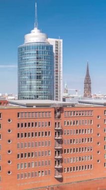 Modern Hamburg, Almanya 'nın hava zaman çizelgesi, konut ve ofis binalarının kırmızı tuğla cephelerini gösteriyor. Çok katlı evler ve kuleler bu canlı kentsel alanda çarpıcı bir şehir manzarası yaratıyor.