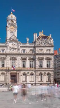 Hotel de Ville de Lyon 'dan Hyperlapse, Fransa' nın tarihi Lyon belediye binası. Kare zaman diliminde insanlar fıskiyenin yanında geziniyor. Mavi gökyüzünün altında bir barok ve klasik mimari mucize.