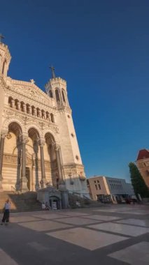 Fransa 'nın Lyon kentinde günbatımında Notre Dame de Fourviere Bazilikası' nın hiperlapse ön görüntüsü. Bu ikonik küçük bazilika sıcak ışıkla aydınlatılıyor. Tepenin tepesindeki zaman diliminden şehre bakıyor.