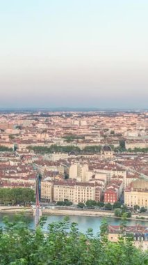 Gün batımında Fourviere Hill 'den Lyon' un panoramik hava görüntüsü. Ufuk çizgisinde Pont Marechal Juin, Rhone Nehri ve sıcak akşam ışığında aydınlanan ikonik şehir simgeleri yer alıyor.
