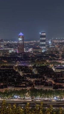 Geceleri Fourviere Hill 'den gökdelenlerle Lyon' un panoramik hava manzarası. Ufuk çizgisinde Rhone Nehri ve ikonik kent simgeleri yer alıyor. Evler çatılar ve caddelerde trafik