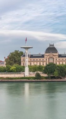 Fransa 'nın Lyon kentindeki Jean-Moulin Üniversitesi' nin yer aldığı Rhone Nehri 'nin panoramik hiperhızlandırılmış manzarası ve seti. Parçalı bulutlu bir gökyüzü zaman diliminin altında Üniversite Köprüsü ve rıhtımını içerir