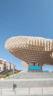 Encarnacion Meydanı 'ndaki Metropol Şemsiyesi zaman atlaması, panoramik yürüyüş yolu ve bir arkeoloji müzesi olan fütürist ahşap yapı. Mavi gökyüzü, merdivenler, trafik ve şehir manzarası Sevilla, İspanya