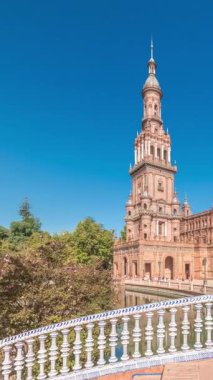 Panorama, Seville Timelapse 'de Plaza de Espana' yı gösteriyor. Maria Luisa Park 'ta Ibero-American Exposition için inşa edilmiş büyük bir mimari kompleks. Mavi gökyüzünün altında köprüler, kanallar ve klasik sokak lambaları