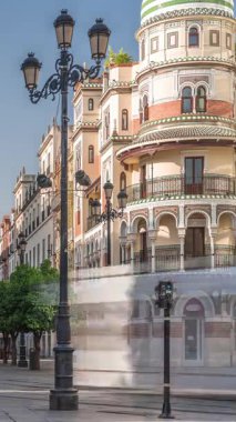 Avda boyunca yürüyen yayalar. De la Constitucion, Seville, İspanya 'nın Casco Antiguo bölgesindeki ana cadde. Edificio de la Adriatica yakınlarındaki zaman dilimi, tarihi binalar ve geçen tramvaylar