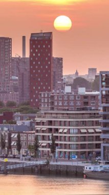 Hollanda, Rotterdam 'da gün batımında Katendrecht Yarımadası ve Maashaven Limanı' nın panoramik zaman çizelgesi. Şehir silueti, modern gökdelenler ve geleneksel Hollanda rıhtım evleri