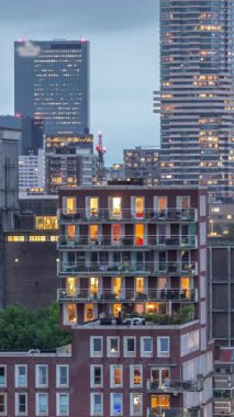 Rotterdam, Hollanda 'daki Katendrecht yarımadası ve Maashaven limanının hava ve gece geçiş zamanı. Günbatımından sonra parlayan pencereleri olan modern gökdelenler.