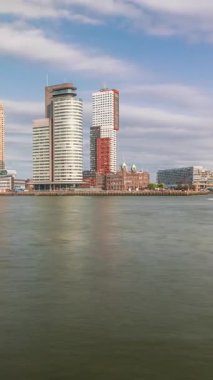 Panorama, Nieuwe Maas River bankasından Wilhelminapier ve Kop van Zuid 'e kadar olan zaman çizelgesini gösteriyor. Modern gökdelenler, gemi terminali ve Erasmus Köprüsü, kıyıdan geçen tekneler.