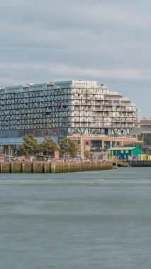 Rotterdam şehir merkezindeki Hotel New York tarihi cepheli modern binaların zaman çizelgesi. Eski Hollanda-Amerika Hat Karargahı. Tekneler geçerken insanlar rıhtımda dinleniyor. Simgesel mimari