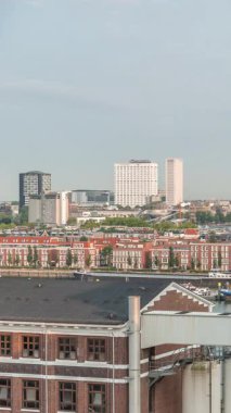 Rotterdam, Hollanda 'daki Katendrecht Yarımadası ve Maashaven Limanı' nın panoramik zaman çizelgesi. Sabah şehir silueti, modern gökdelenler ve Hollanda kıyısı evleri olan eski fabrikalar.
