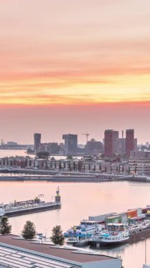 Rotterdam, Hollanda 'daki Katendrecht Yarımadası ve Maashaven Limanı' nın panoramik hava ve gece geçiş zamanı. Şehir silueti modern gökdelenler ve geleneksel Hollanda rıhtım evleri