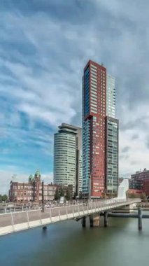 Hollanda, Rotterdam 'da bulunan ve yerel olarak Hoerenloper olarak bilinen Rijnhaven Köprüsü' nden Hiperlapse. Arka planda modern gökdelenleri ve bulutlu gökyüzü olan bir yaya ve bisiklet köprüsü