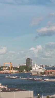 Arka planda Katendrecht ve Maas Nehri 'nin yer aldığı Maashaven' ın havadan görüntüsü. Sıcak sabah ışığıyla gökdelenlerin üzerinde dramatik bulutlu bir gökyüzü. Arkaplanda kargo portu