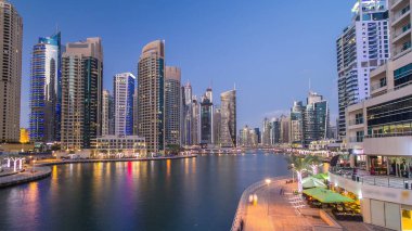 Dubai Marina rıhtımı, Dubai 'deki köprüden gece vardiyasına kadar uzanan kuleleri ve yatları olan Birleşik Arap Emirlikleri. Yapay kanalları ve gökdelenleri olan bir bölge.