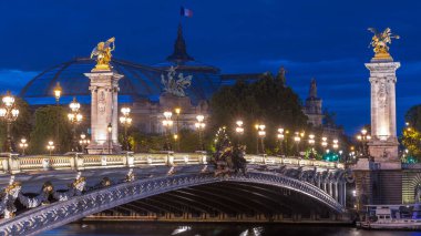 Paris 'teki Alexandre Köprüsü gece gündüz aydınlandı geçiş zamanı. Gün batımından sonra Grand Palais 'de. Trafik sıkışık. Paris, Fransa