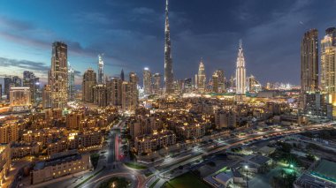 Dubai şehir merkezi silueti Burj Halife ve diğer panoramik manzaralı Dubai, Birleşik Arap Emirlikleri. Geleneksel ve modern binalar. Çevre yolunda trafik ve gün batımından sonra çeşmeler