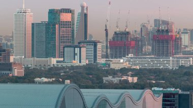 Dubai şehir merkezi mimarisi ile Aerial cityscape ve günlük geçiş timelapse, Birleşik Arap Emirlikleri finans merkezi gece. Şantiye ile en yüksek kuleler ve gökdelenler